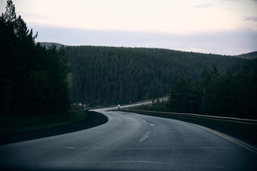 Evening highway in the mountains. Deserted road in the mountains in the evening.