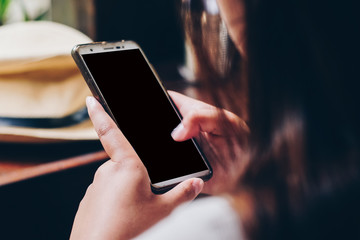 Women use smartphone on hand in cafe