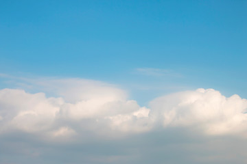Blue sky with soft white clouds.