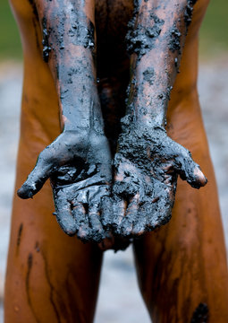 Hands of a borana tribe man picking up salt from the lake of el sod volcano, Yabello, Omo valley, Ethiopia