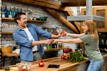 Lovely cheerful young couple cooking dinner together