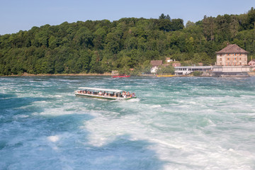 Obraz premium Boat with people floating to the waterfall the Rhine Falls