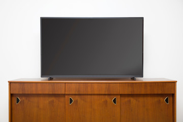 Modern TV set with empty blank screen on the wooden cabinet