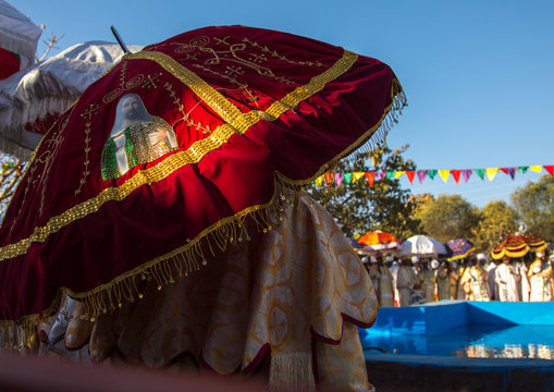 Priests with umbrellas in front of the pool during timkat celebrations of epiphany, Amhara region, Lalibela, Ethiopia