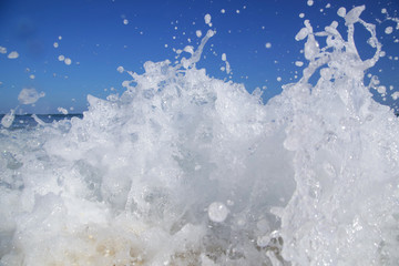Close up view at beautiful wild ocean wave hitting the shore