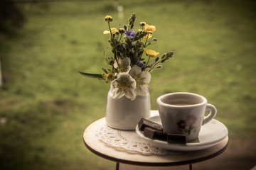 cup of coffee with flowers on wooden background