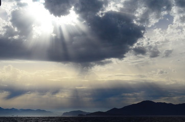 the setting sun in the clouds over the Aegean Sea
