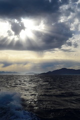 the setting sun in the clouds over the Aegean Sea