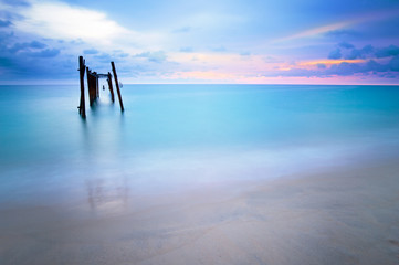 Decay bridge reflection in smooth sea surface..Long exposure shot of old wooden bridge at Khao pilai beach at sunset ..
