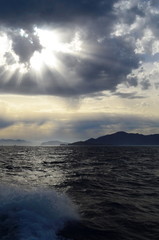 Naklejka na ściany i meble the setting sun in the clouds over the Aegean Sea