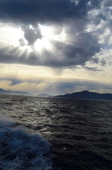 the setting sun in the clouds over the Aegean Sea