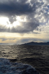 the setting sun in the clouds over the Aegean Sea