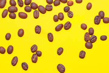 Coffee beans isolated on the yellow background. Joyful minimal coffee-theme with copy space
