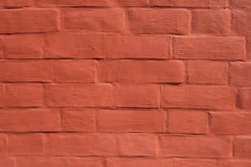 Red brick wall with smooth seams, covered with lime or plaster