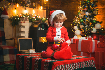 christmas stocking. Christmas miracle and new year feelings. A little boy in warm clothes sitting...