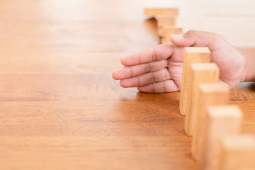 Hand stop wooden block. Domino risk effect concept