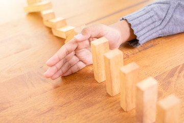 Hand stop wooden block. Domino risk effect concept