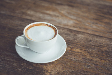 White ceramic coffee cup on wooden table or counter