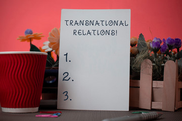 Handwriting text writing Transnational Relations. Conceptual photo International Global Politics Relationship Diplomacy Flowers and stationary plus plain sheet with paper big cup above a table