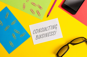 Text sign showing Consulting Business. Business photo text Consultancy Firm Experts give Professional Advice Paper sheets pencil clips smartphone eyeglasses notebook color background