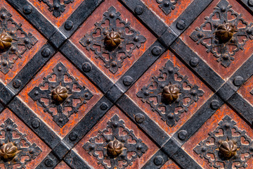 Ancient  gate with metal mounting and ironworks.  Beautiful decorative metal elements forged wrought iron gates.