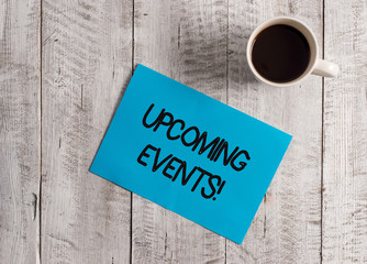 Text sign showing Upcoming Events. Business photo showcasing thing that will happens or takes place soon planned occasion Pastel Colour paper placed next to a cup of coffee above the wooden table