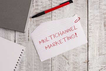 Handwriting text Multichannel Marketing. Conceptual photo for a consumer to buy from whatever way is easier Torn paper and notebook sheet with a pen placed on top of wooden table