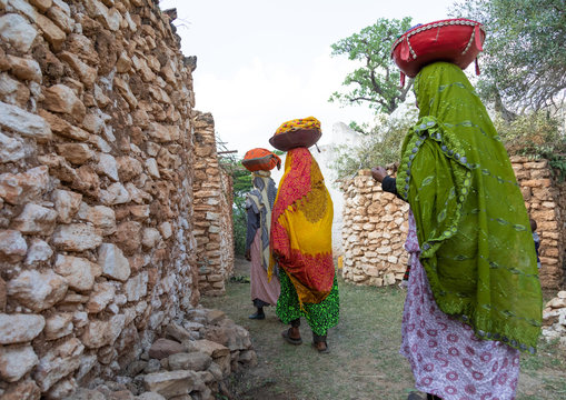 Harari women bringing injeras in baskets on their heads for a muslim celebration, Harari region, Harar, Ethiopia