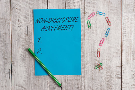Handwriting text Non Disclosure Agreement. Conceptual photo Legal Contract Confidential Material or Information Pastel colour note paper placed next to stationary above the wooden table