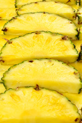 Pineapple juicy yellow slices background. Top view.