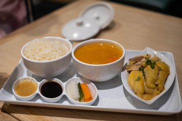 Hainanese chicken rice with sauce soup and salad.