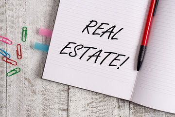 Conceptual hand writing showing Real Estate. Concept meaning owning property consisting of empty land or buildings Notebook stationary placed above classic wooden backdrop