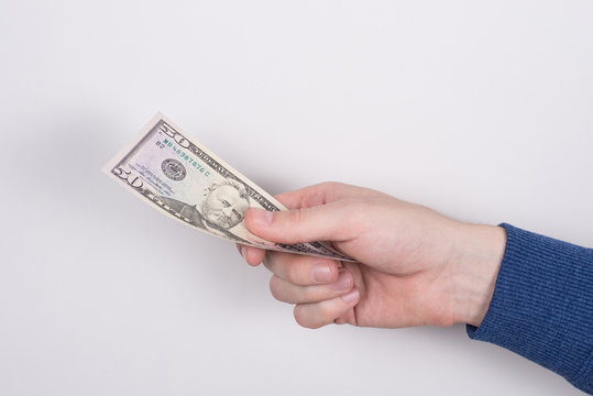 Cropped closeup side profile photo of worker's hand giving one paper us money isolated grey background