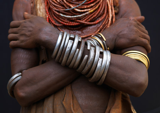 Detail of karo woman chest wearing metal bracelets and beaded necklaces, Crossed arms omo valley ethiopia