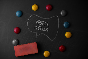 Handwriting text writing Medical Checkup. Conceptual photo thorough physical examination includes variety of tests Round Flat shape stones with one eraser stick to old chalk black board