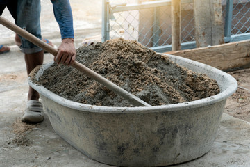 Construction worker : Using a shovel to mix cement in a pickup truck for construction