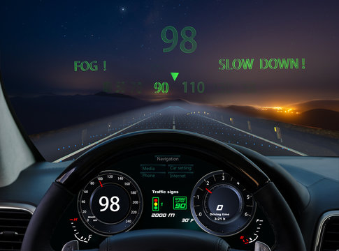 view from the cockpit of a car equipped with HUD and active safety systems.Systems detected fog on a mountain road at night and reduced speed automatically - Powered by Adobe