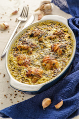 Fried chicken cooked in a creamy sauce with garlic. Large portion in a deep dish. Close up and vertical view.