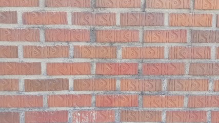 Obraz premium A background of a weathered old exterior brick wall in the sunshine.