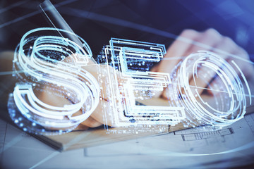 Multi exposure of woman's hands making notes with SEO icon. Concept of Search engine optimization