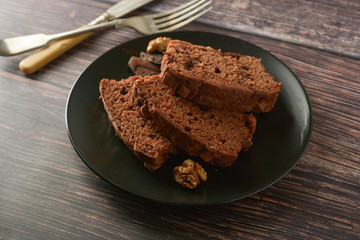 Piece of chocolate cake , fudge or pound cake. Wooden background.