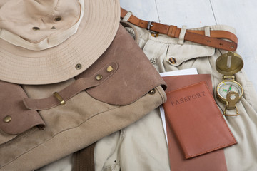 Prepare for journey in safari style, hiking and backpacker - accessories and travel items, packing clothes in backpack: backpack, passport, tickets, hat