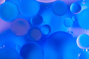 oily drops in water with colorful background, close-up 