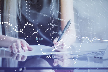 Double exposure of woman's writing hand on background with data technology hud. Big data concept.