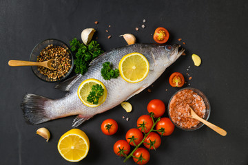 Fresh fish seabass and ingredients for cooking.