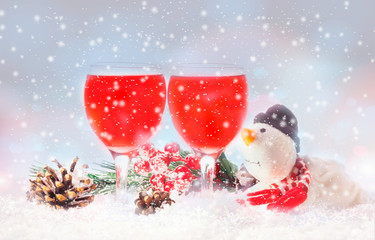 christmas toys, wine glasses and snowman against in Christmas lights.