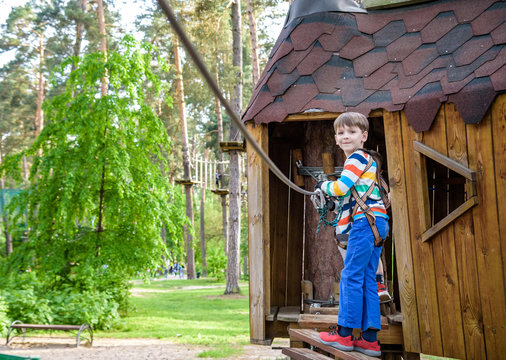 Boy climbing up into a treehouse. Healthy games outdoor.