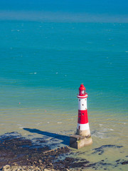 View of the white chalk headland cliffs and Beachy Head Lighthouse in Seven Sisters National park, Eastbourne, East Sussex, England, UK.