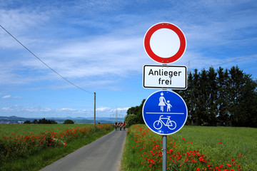 Asphaltierter Feldweg und Verkehrsschilder Verbot für Fahrzeuge aller Art mit Zusatzschild...