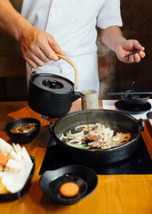 Chef is pouring Shabu sauce mix with fried onion, scallion and beef fat before boiling Wagyu beef and Kurobuta pork.